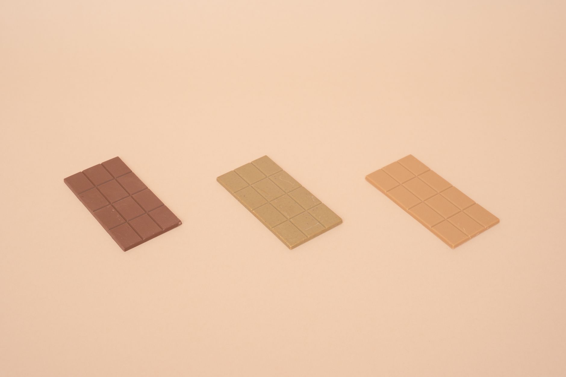 ベージュの背景に置かれた3本のチョコレートバー