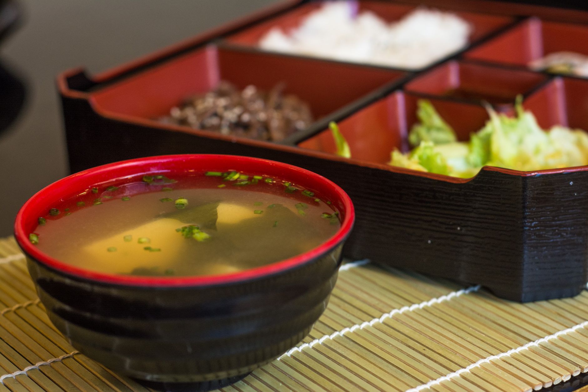 黒い器に盛られた豆腐とねぎのみそ汁